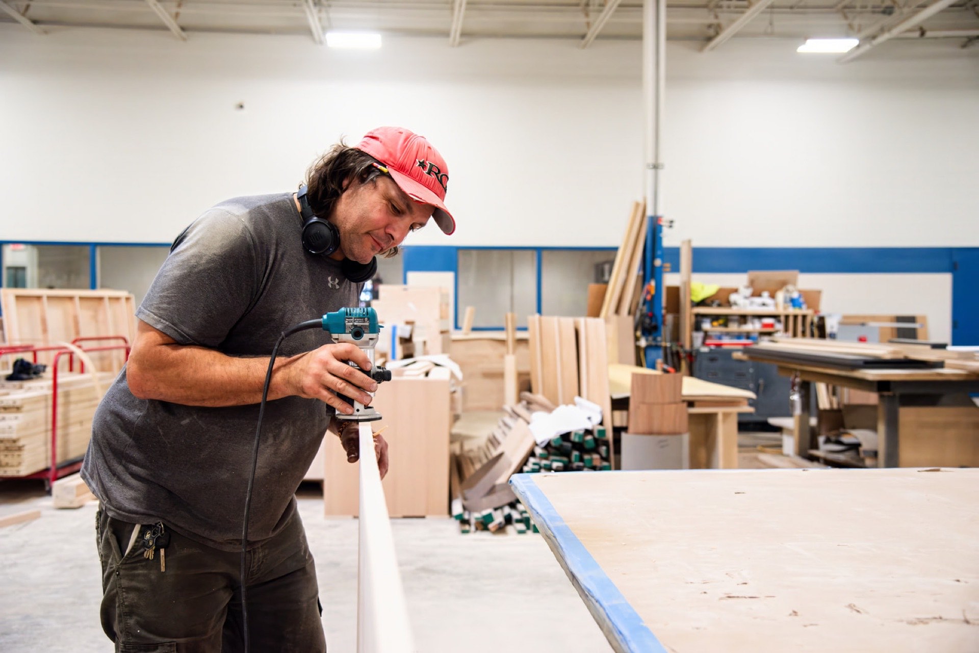 Carpenter routing a trim profile by hand
